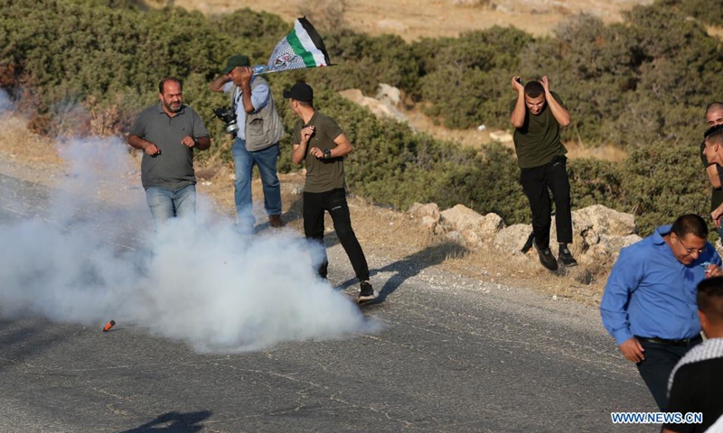 Palestinian protesters run to take cover from tear gas canisters fired by Israeli soldiers during clashes following a protest against the expanding of Jewish settlements at Tayasir checkpoint, east of the West Bank city of Tubas, July 31, 2021.(Photo: Xinhua)
