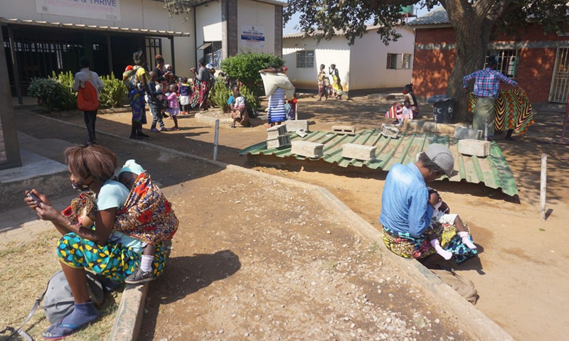 Beneficiaries of the food supplement program run by the Women's Federation for World Peace in Zambia wait for rations at a health facility in Lusaka, Zambia, on July 23, 2021.(Photo: Xinhua)