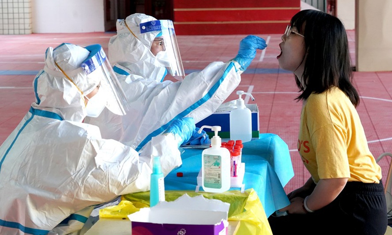 A medical worker takes a swab sample from a resident for nucleic acid testing in Zhengzhou, central China's Henan Province, Aug 2, 2021.Photo:Xinhua