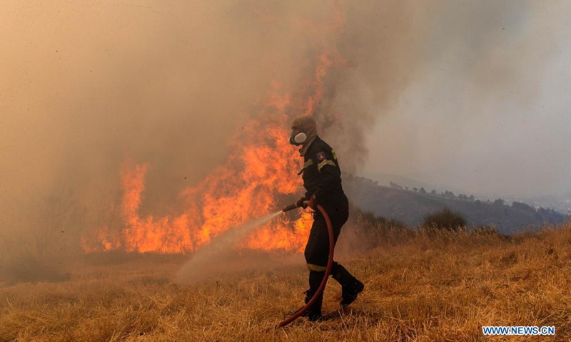 A firefighter tries to put out a fire in Afidnes, some 30 kilometers away from the Greek capital of Athens, on Aug. 6, 2021. Greek authorities said on Friday that three people have been arrested for suspected arson, as devastating wildfires continue to scorch thousands of hectares of forest land across the country.Photo:Xinhua