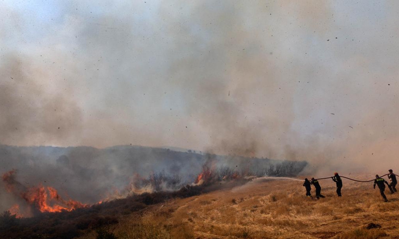 Firefighters try to put out a fire in Afidnes, some 30 kilometers away from the Greek capital of Athens, on Aug. 6, 2021. Greek authorities said on Friday that three people have been arrested for suspected arson, as devastating wildfires continue to scorch thousands of hectares of forest land across the country.Photo:Xinhua