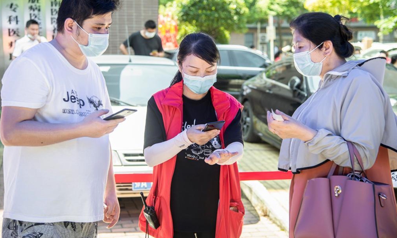 A community worker helps residents with nucleic acid testing registry in Wuhan, central China's Hubei Province, Aug. 4, 2021. Photo:Xinhua