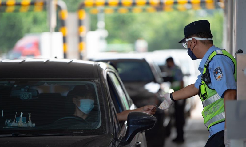Policemen check information of people entering Beijing at a road checkpoint in Beijing, capital of China, Aug. 6, 2021. Photo:Xinhua