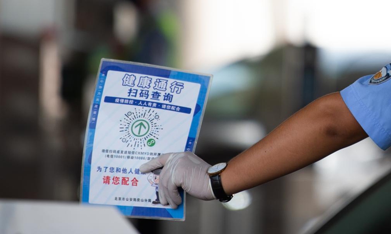 A policeman asks people entering Beijing to scan a QR code to register travel information at a road checkpoint in Beijing, capital of China, Aug. 6, 2021. Photo:Xinhua