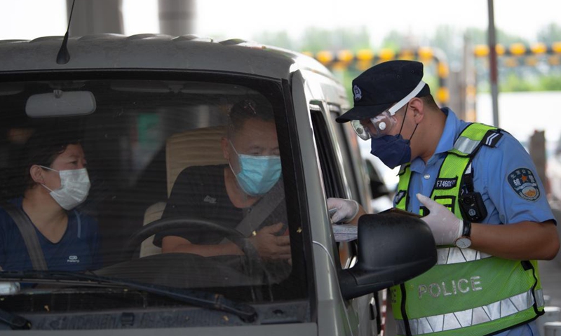 A policeman checks information of people entering Beijing at a road checkpoint in Beijing, capital of China, Aug. 6, 2021. Photo:Xinhua
