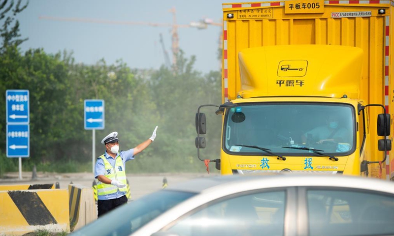 A policeman guides traffic at a road checkpoint in Beijing, capital of China, Aug. 6, 2021. Beijing has stepped up the screening of people entering the city from areas with reported COVID-19 cases. Airports and traffic nodes in the city are being asked to strengthen their prevention and control measures to halt the spread of the coronavirus. 