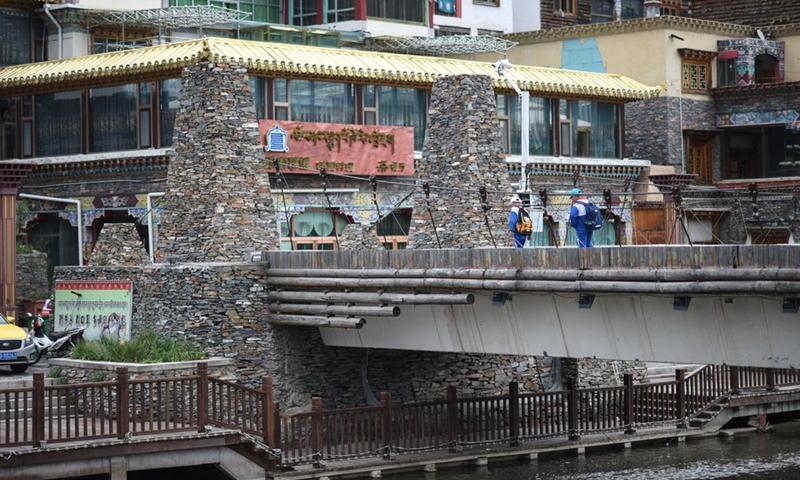 Two students walk on a bridge in Yushu City, Yushu Tibetan Autonomous Prefecture, northwest China's Qinghai Province, Aug. 6, 2021. (Photo: Xinhua)