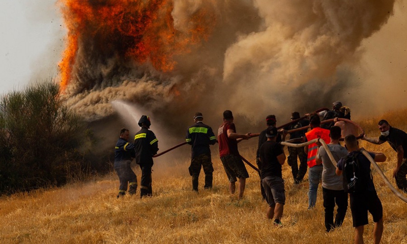 Firefighters and volunteers try to put out a fire in Afidnes, some 30 kilometers away from the Greek capital of Athens, on Aug. 6, 2021.(Photo: Xinhua)