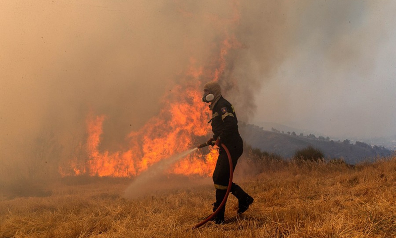 Ένας πυροσβέστης προσπαθεί να σβήσει φωτιά στις Αφίδνες, περίπου 30 χιλιόμετρα από την ελληνική πρωτεύουσα, Αθήνα, στις 6 Αυγούστου 2021.  (Φωτογραφία: Xinhua)