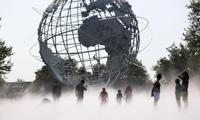 People cool off in the mist garden near the Unisphere in Flushing Meadows Corona Park in New York, the United States, Aug. 13, 2021. A heat wave recently hit New York City.Photo:Xinhua