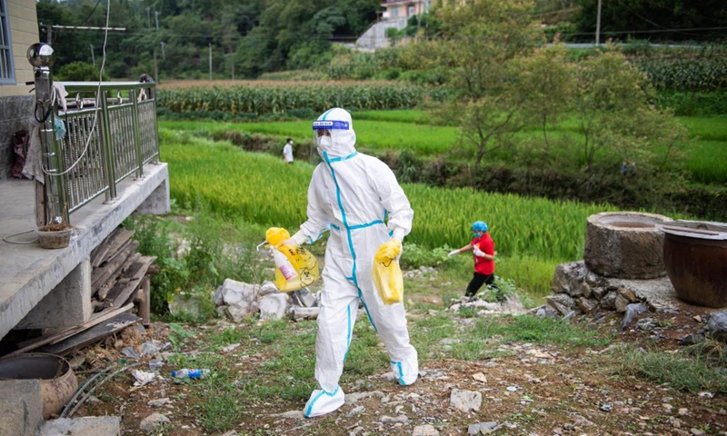 Luo Jinwu walks to offer door-to-door nucleic acid sampling services in Yangping Village of Yongding District in Zhangjiajie City, central China's Hunan Province, Aug. 12, 2021.Photo:Xinhua