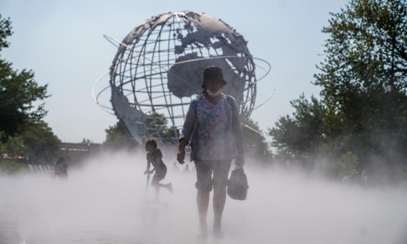 People cool off in the mist garden near the Unisphere in Flushing Meadows Corona Park in New York, the United States, Aug. 13, 2021. A heat wave recently hit New York City.Photo:Xinhua