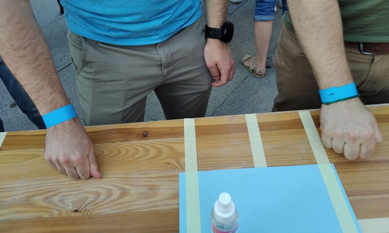 People knock on wooden tables simultaneously in an attempt to set a Guinness World Record in Sofia, Bulgaria, on Aug. 13, 2021.(Photo: Xinhua)
