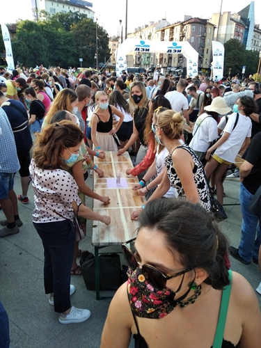 People knock on wooden tables simultaneously in an attempt to set a Guinness World Record in Sofia, Bulgaria, on Aug. 13, 2021.(Photo: Xinhua)