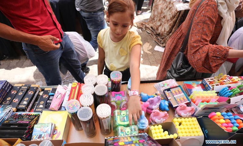 A Palestinian girl shops at a market ahead of the new school year in the West Bank city of Nablus, Aug. 14, 2021.(Photo: Xinhua)