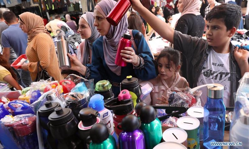 Palestinians shop at a market ahead of the new school year in the West Bank city of Nablus, Aug. 14, 2021.(Photo: Xinhua)