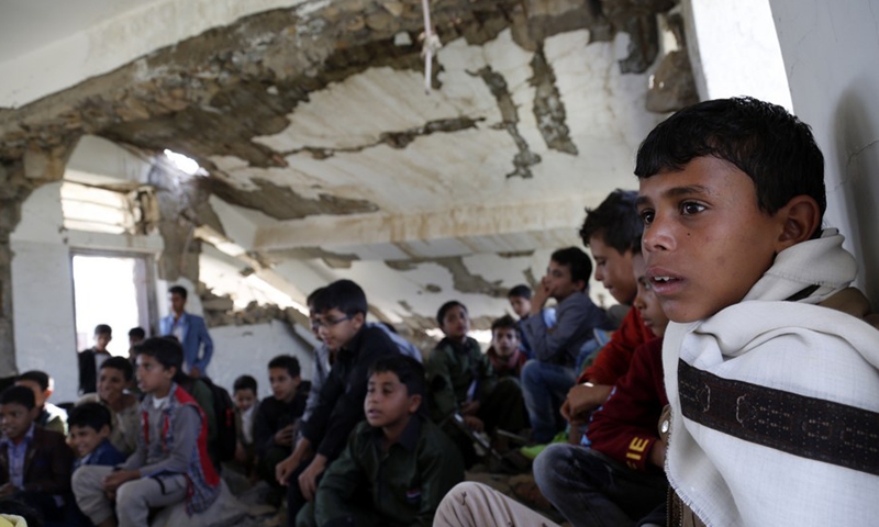 Students sit on the ground inside a half-collapsed building at Shuhada-Alwahdah School in Al-Radhmah district of Ibb province, Yemen, Aug. 14, 2021.(Photo: Xinhua)