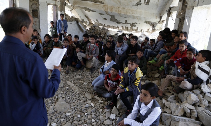 Students have a class while sitting on the ground inside a half-collapsed building at Shuhada-Alwahdah School in Al-Radhmah district of Ibb province, Yemen, Aug. 14, 2021.(Photo: Xinhua)