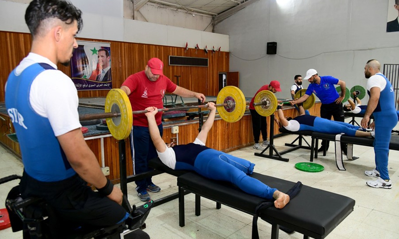 Syrian veterans with reduced mobility receive weight lifting exercises at a training camp in Damascus, Syria, on August 16, 2021. (Photo: Xinhua)