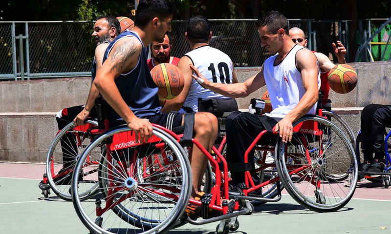Syrian veterans with physical impairment play wheelchair basketball at a training camp in Damascus, Syria, on Aug. 16, 2021. (Photo: Xinhua)