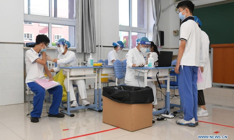 Medical workers administer doses of COVID-19 vaccine to students at the Hangtian Campus of the Beijing Yuying School in Beijing, capital of China, on Aug. 21, 2021.Photo:Xinhua