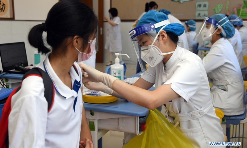 A medical worker administers a dose of COVID-19 vaccine to a girl student at the Hangtian Campus of the Beijing Yuying School in Beijing, capital of China, on Aug. 21, 2021.Photo:Xinhua