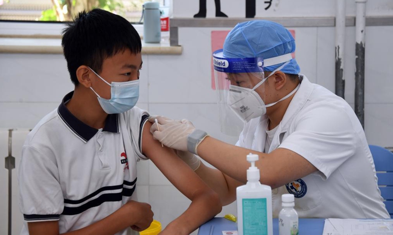 A medical worker inquires a girl student of her health condition before she receives a dose of COVID-19 vaccine at the Hangtian Campus of the Beijing Yuying School in Beijing, capital of China, on Aug. 21, 2021.Photo:Xinhua