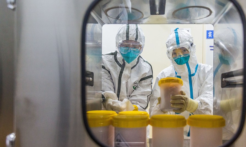 Staff members receive the novel coronavirus strain transported from Zhejiang Provincial Center for Disease Control and Prevention, at a laboratory of Chinese Center for Disease Control and Prevention, in Beijing, capital of China, Feb. 25, 2020.Photo:Xinhua