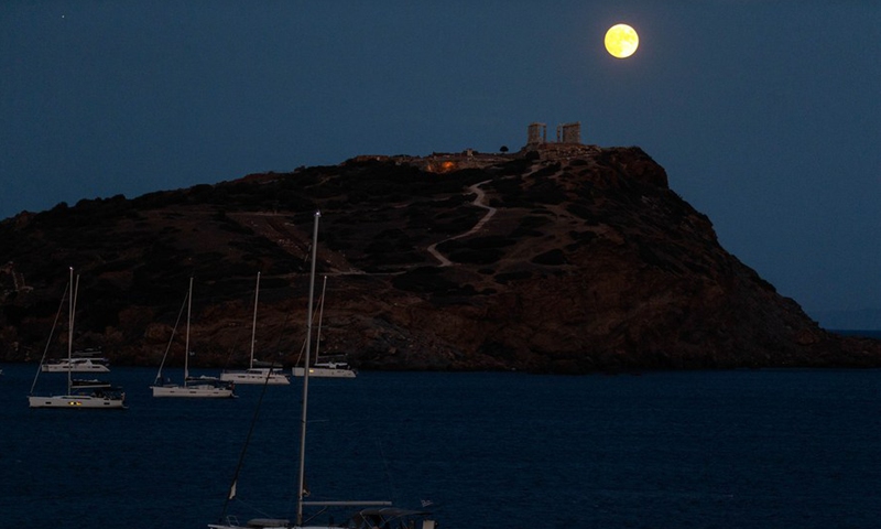 A full moon is seen over the Temple of Poseidon at cape Sounion, some 70 km southeast of Athens, Greece, on Aug. 21, 2021.(Photo: Xinhua)