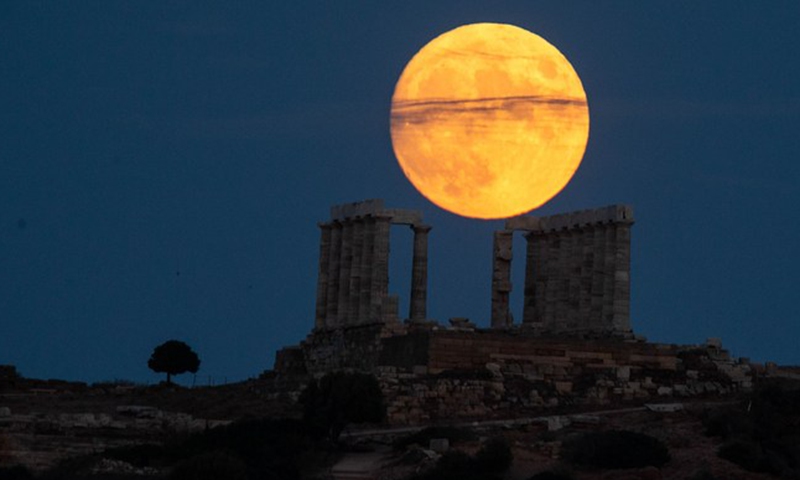 A full moon is seen over the Temple of Poseidon at cape Sounion, some 70 km southeast of Athens, Greece, on Aug. 21, 2021.(Photo: Xinhua)