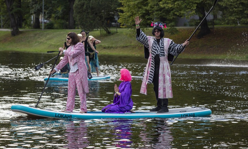 People participate in a stand-up paddleboarding carnival in Riga, Latvia, on Aug. 20, 2021.(Photo: Xinhua)