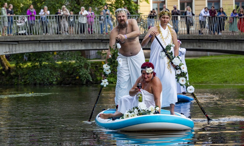 People participate in a stand-up paddleboarding carnival in Riga, Latvia, on Aug. 20, 2021.(Photo: Xinhua)