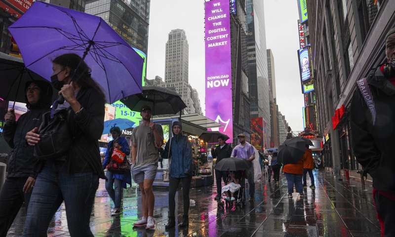 Pedestrians walk in the rain caused by tropical storm Henri, in Times Square in New York, the United States, on Aug. 22, 2021. (Photo: Xinhua)