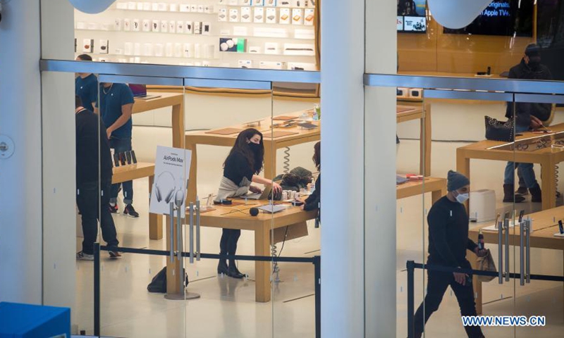 Apple store employees assist customers at the Westfield World Trade Center shopping mall in New York, the United States, January 28, 2021. Photo: Xinhua