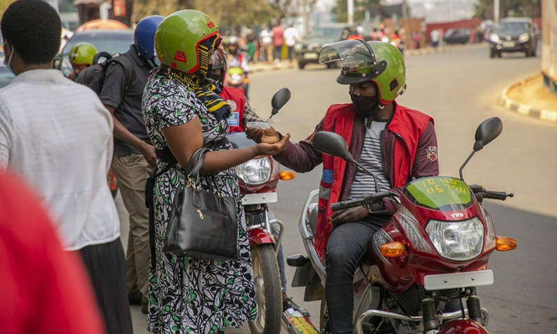 A motorist provides sanitizer to a customer in Kigali, capital of Rwanda, on Aug. 6, 2020.(Photo: Xinhua)