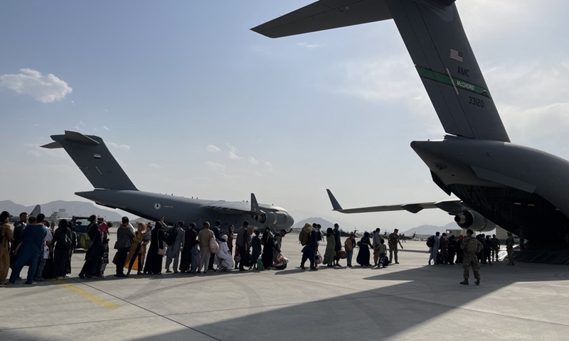 People queue up to board a military aircraft of the United States and leave Kabul at Kabul airport, Afghanistan, Aug. 22, 2021. (Photo: Xinhua)