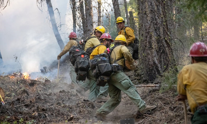 Firefighters work in an area hit by the Dixie Fire near Greenville town in Northern California, the United States, on Aug. 19, 2021.(Photo: Xinhua)