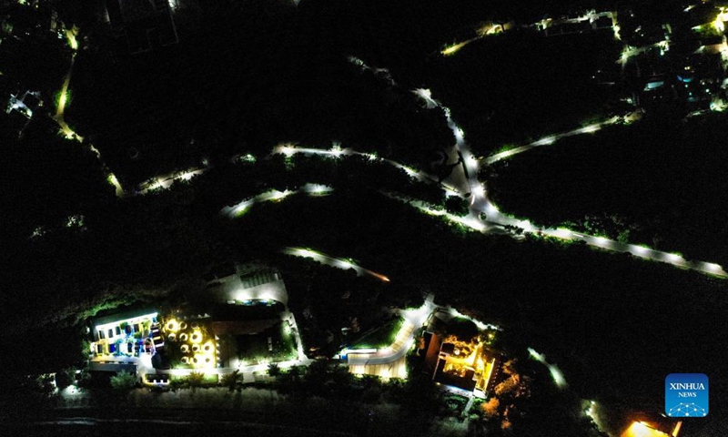 Aerial photo taken on Aug. 27, 2021 shows solar powered street lamps lighted up along a road in Weizhou Township of Beihai City, south China's Guangxi Zhuang Autonomous Region. More and more solar powered street lamps have been erected in areas tucked away in the mountains in Guangxi, illuminating the night sky for people living there.Photo:Xinhua
