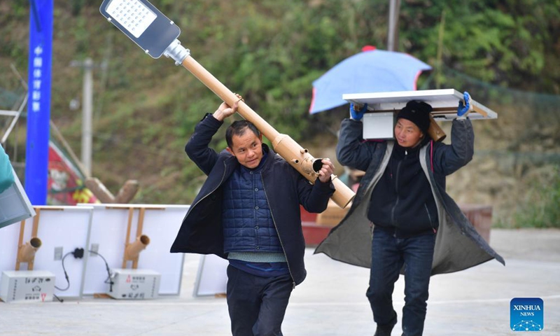 File photo taken on Dec. 1, 2020 shows villagers walking to install a solar powered street lamp in Dangjiu Village of Rongshui Miao Autonomous County, south China's Guangxi Zhuang Autonomous Region. More and more solar powered street lamps have been erected in areas tucked away in the mountains in Guangxi, illuminating the night sky for people living there.Photo:Xinhua