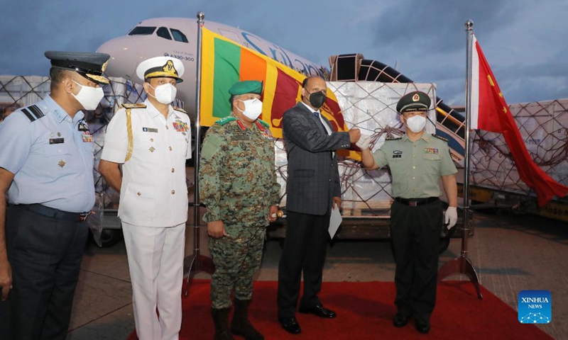 Wan Dong (1st R), defence attaché of the Chinese Embassy to Sri Lanka, and Kamal Gunaratne (2nd R), Sri Lankan Defence Secretary General, bump fists at the handover ceremony for a batch of Sinopharm COVID-19 vaccine donated by the People's Liberation Army (PLA) of China, at Bandaranaike International Airport in Colombo, Sri Lanka, on Aug. 28, 2021. Sri Lanka's Defense authorities on Saturday received a batch of 300,000 doses of Sinopharm COVID-19 vaccine, donated by the PLA of China.(Photo: Xinhua)