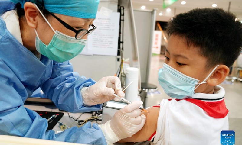 A medical worker administers a dose of the COVID-19 vaccine to a boy at a vaccination site in Xuhui District of Shanghai, east China, Sept. 3, 2021.Photo:Xinhua