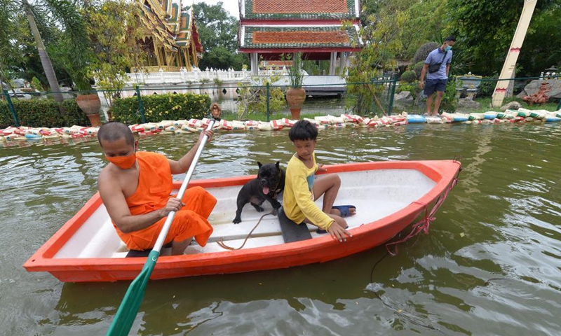 A monk rows a boat through a flooded road on the outskirts of Bangkok, Thailand, on Sept. 3, 2021.Photo:Xinhua