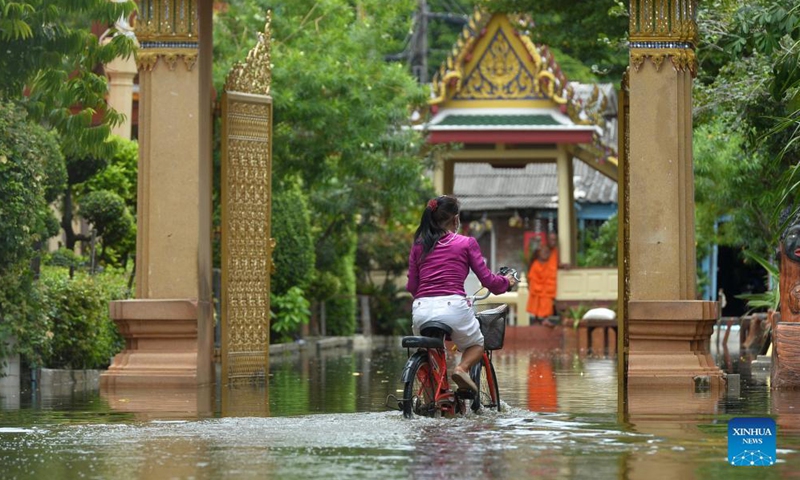 A woman rides a bicycle through a flooded road on the outskirts of Bangkok, Thailand, on Sept. 3, 2021.Photo:Xinhua