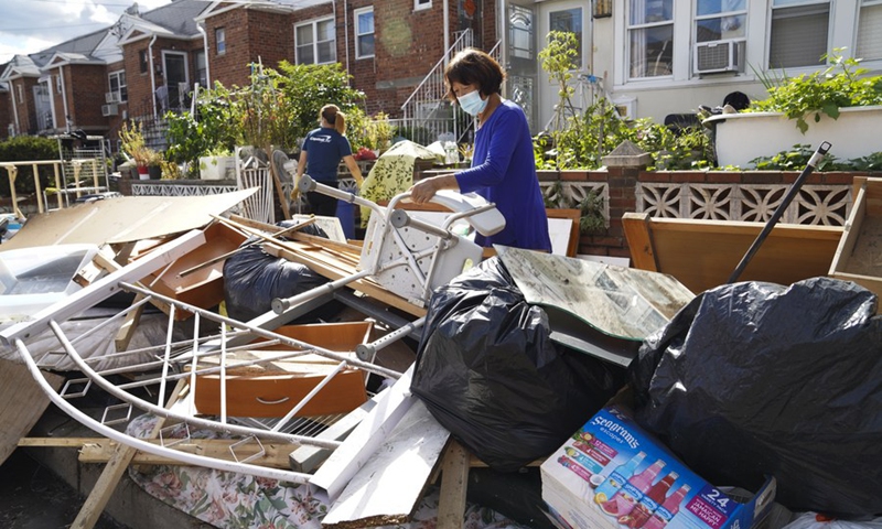 A resident sorts waterlogged furniture outside a house, in the Flushing neighborhood of the Queens borough of New York, the United States, Sept. 3, 2021.(Photo: Xinhua)