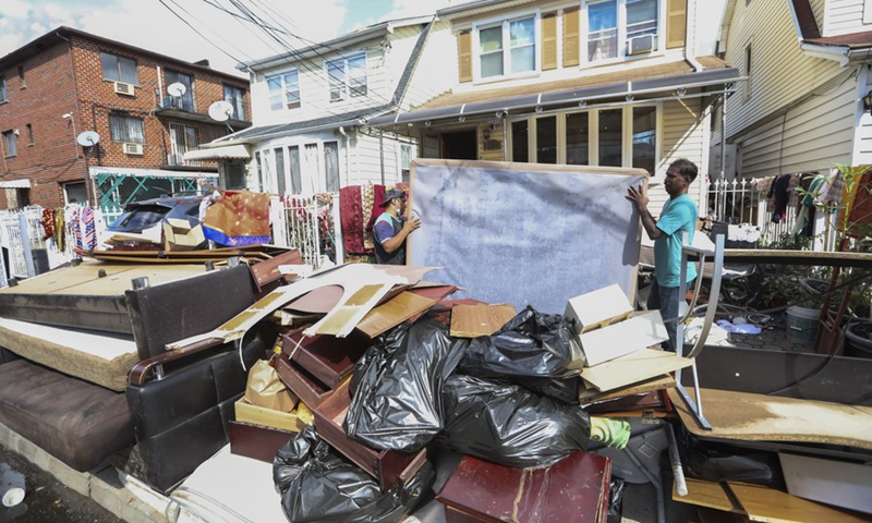People move waterlogged belongings outside a house, in the Flushing neighborhood of the Queens borough of New York, the United States, Sept. 3, 2021.(Photo: Xinhua)