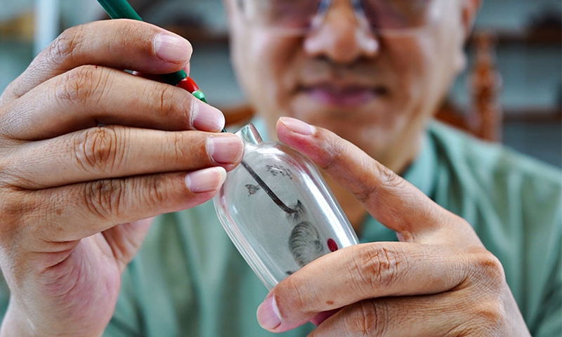 Wang Ziyong creates inside painting work on the inside surface of a snuff bottle at a museum featuring inside paintings in Taocheng District of Hengshui City, north China's Hebei Province, Sept. 4, 2021.(Photo: Xinhua)