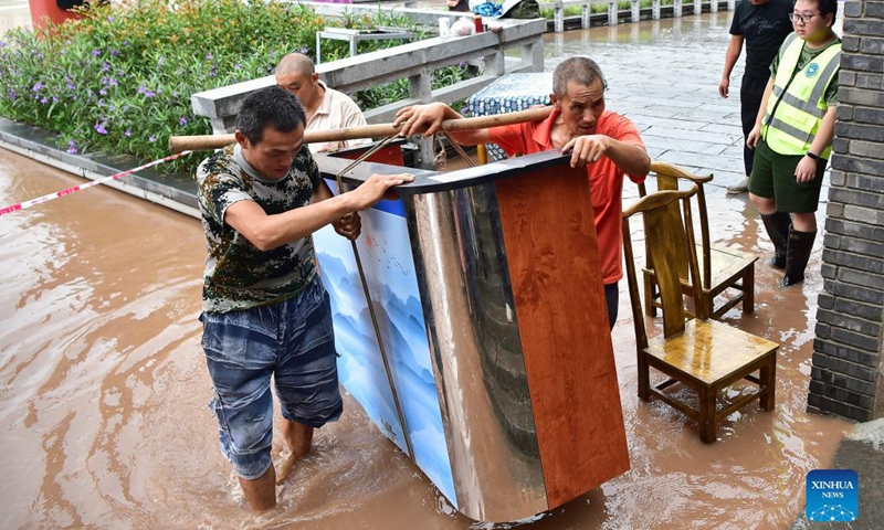 Local citizens transfer furniture to safe place in Ciqikou ancient town, southwest China's Chongqing Municipality, Sept. 6, 2021. The emergency response for flood control was upgraded from level IV to III on Monday, according to Chongqing's flood control and drought relief headquarters, as Jialing River in Chongqing witnessed rapidly increasing water levels following constant heavy rainfall.(Photo: Xinhua)