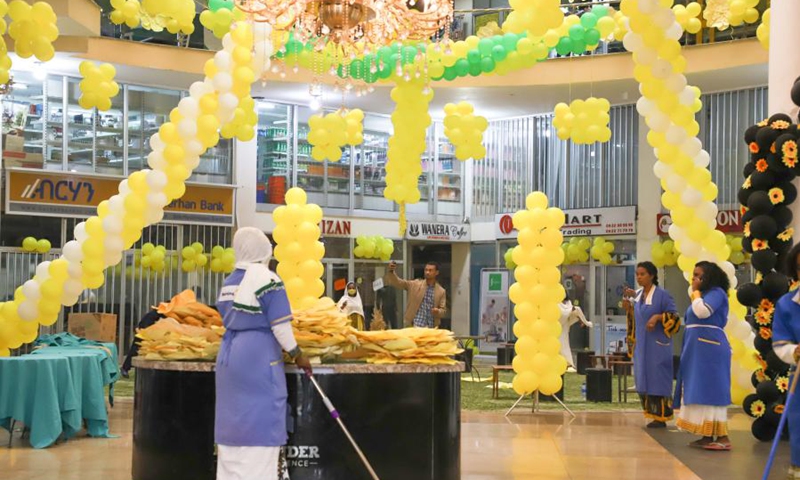 Locals go about their businesses in a mall decorated with balloons and models of daisies in Addis Ababa, capital of Ethiopia, Sept. 11, 2020.(Photo: Xinhua)