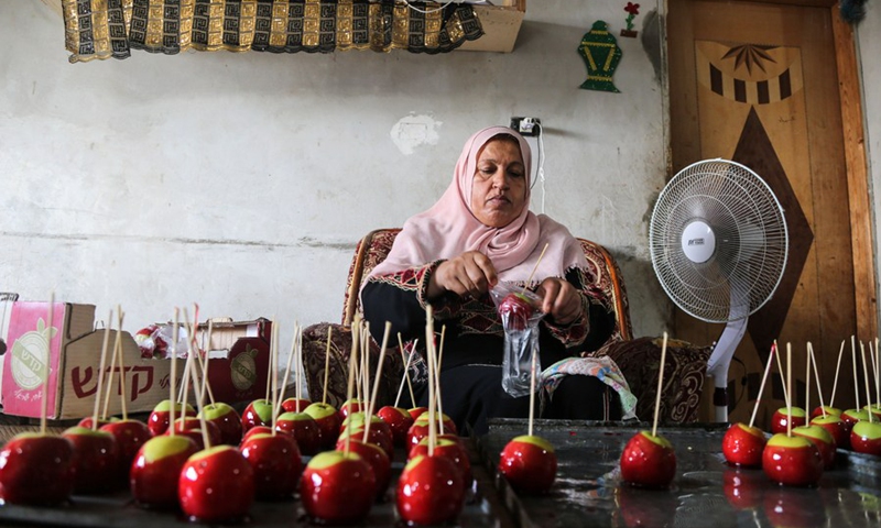 Palestinian woman Hanan Hamad makes candy apples, known as Halawa Anber in Gaza Strip, in her house in the northern Gaza Strip town of Beit Hanoun, on Sept. 14, 2021.(Photo: Xinhua)