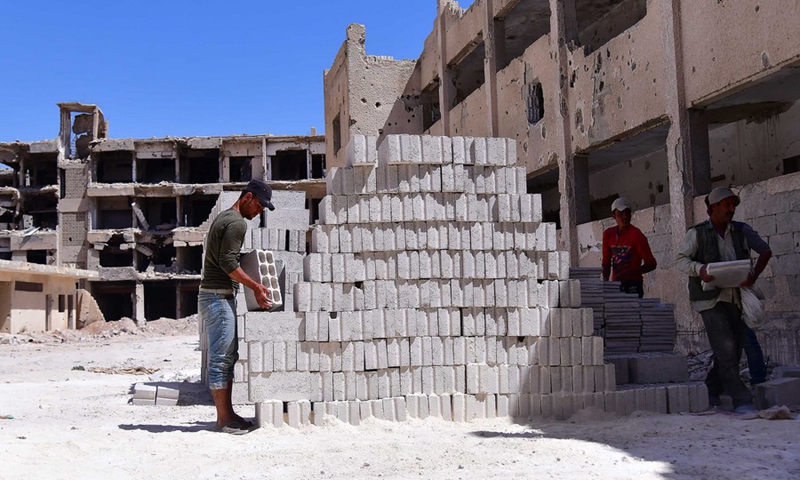 Workers carry bricks for rehabilitation in the Daraya suburb, west of the capital Damascus, Syria, on Sept. 13, 2021.(Photo: Xinhua)